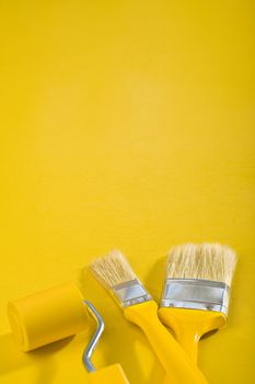 copyspace image Brushes and paint-roller on a yellow background