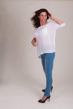 laughing senior model in fashionable jeans with a white blouse