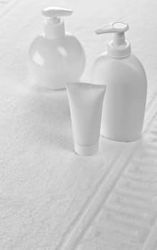 bottles and tube on white towel