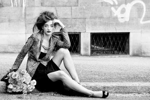 attractive young woman with pink roses outdoor on street
