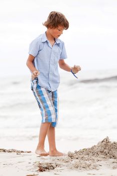 little boy playing in sand on the beach summer holiday fun happiness