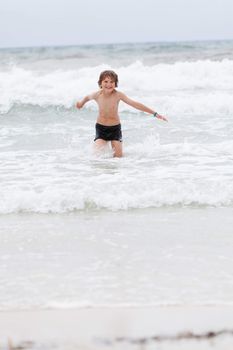 young little boy in water summer holiday having fun sea ocean 