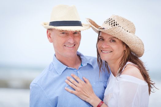 happy adult couple in summertime on beach having fun vacation