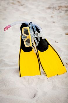 yellow fins and snorkelling mask on beach in summer holiday
