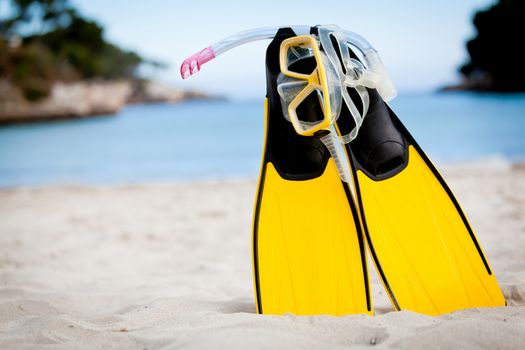 yellow fins and snorkelling mask on beach in summer holiday