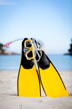 yellow fins and snorkelling mask on beach in summer holiday