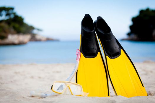 yellow fins and snorkelling mask on beach in summer holiday