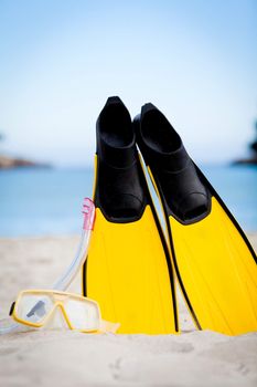 yellow fins and snorkelling mask on beach in summer holiday