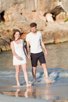 young happy couple walking on beach sunset holiday vacation