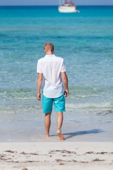 young man walking on the beach in summer holiday vacation
