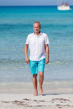 young man walking on the beach in summer holiday vacation