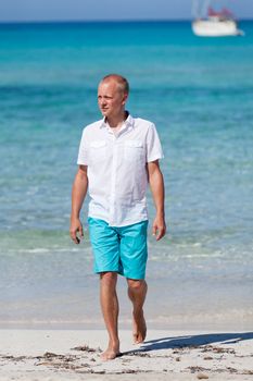 young man walking on the beach in summer holiday vacation