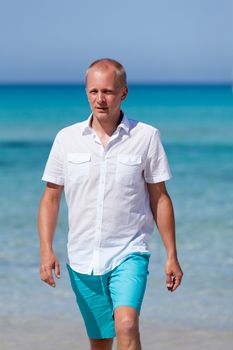 young man walking on the beach in summer holiday vacation