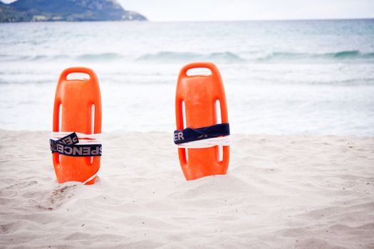 orange red life buoy in sand on beach at the sea object summertime