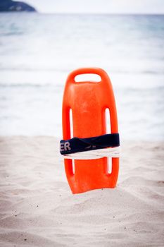 orange red life buoy in sand on beach at the sea object summertime