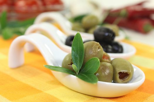 Olives with olive leaves on a spoon