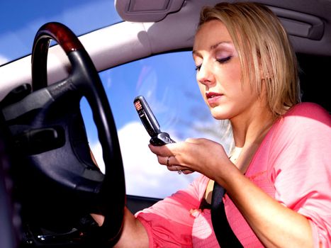 Young Woman Driving Dialing Mobile Telephone. Model Released