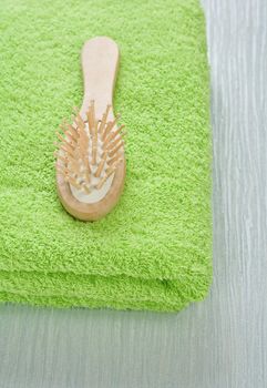 wooden hairbrush on green towel