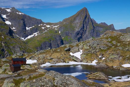 Scenic norwegian panorama with mountain cabin by lake on Lofoten islands