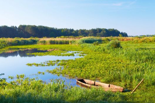 Wooden boat on the lake on a summer morning