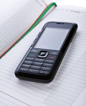 black mobile phone on a notepad