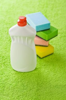 bottle and sponges on green towel