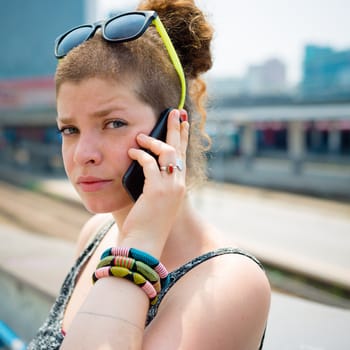 beautiful stylish modern young woman on the phone in the city