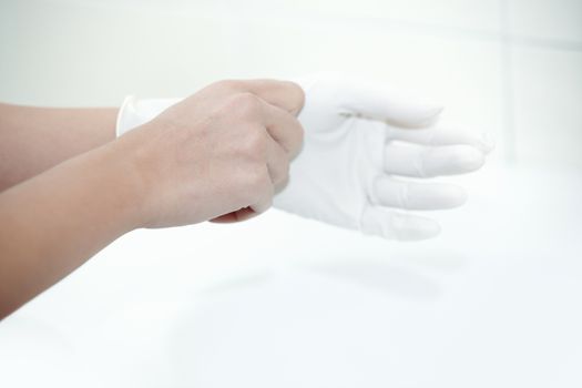 Hands of human taking on rubber gloves