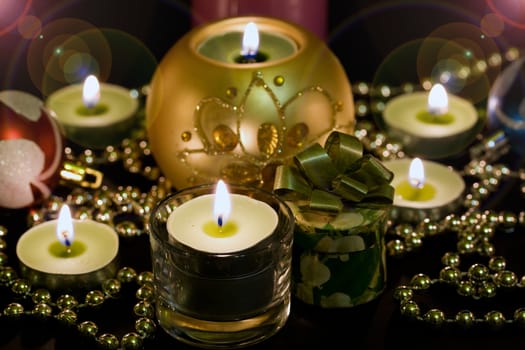 Candles and some bright balls on a black background.