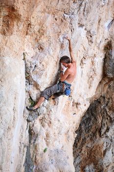 Rock climber on a cliff, vertical view