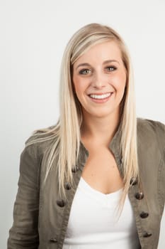 Young blond woman smiling against a white background