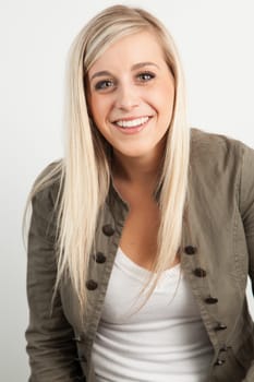 Young blond woman smiling against a white background