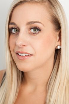 Young blond woman smiling against a white background