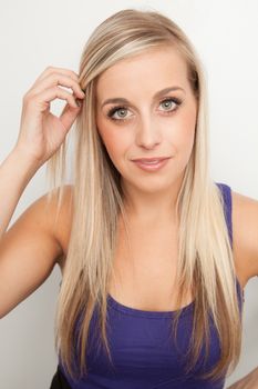 Young blond woman smiling against a white background