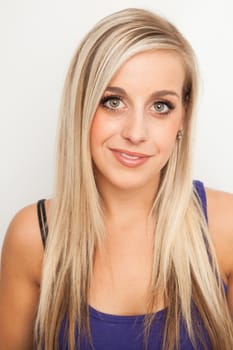 Young blond woman smiling against a white background