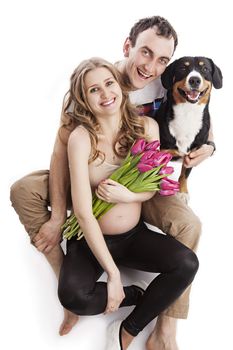 Young pregnant couple and Entlebucher Sennenhund dog over white