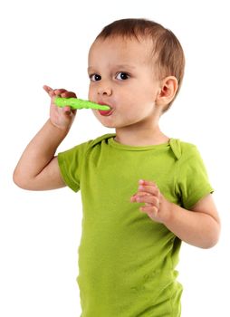 Cute little boy brushing teeth, isolated on white background