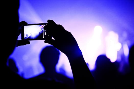 Someone talking a picture during a concert with a phone