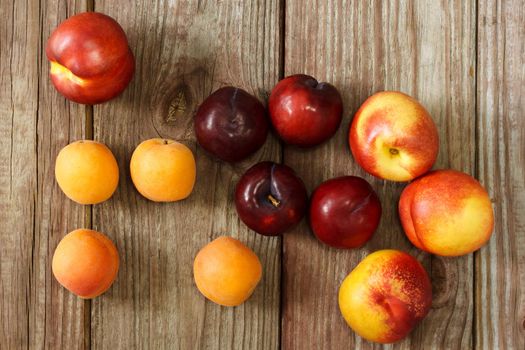 Juicy nectarines and apricots on wooden table