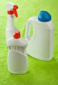 three white bottles on green background