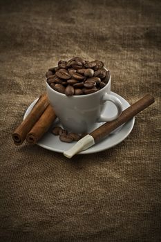 cup with beans cigar and cinnamon