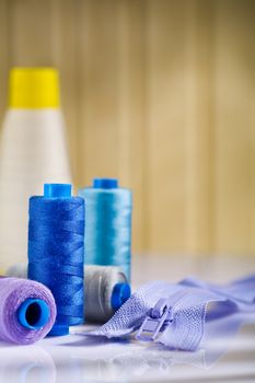 spools and zip on white table