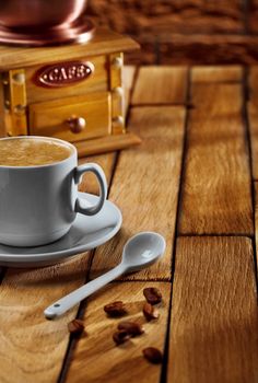 close-up coffee cup and grinder on wooden table