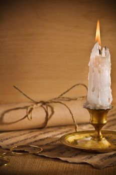 antic candle on table with musical notes