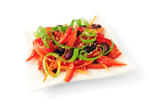 A salad of tomatoes, sweet peppers, red beans, carrots with sesame