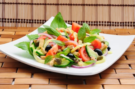 Fresh vegetable salad with basil, capers, olives, marinated with croutons