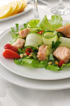 Vegetable salad with boiled salmon and pine nuts