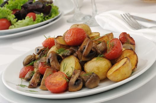Baked potatoes with slices of mushrooms and tomatoes