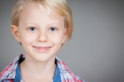 A close-up portrait of a cute happy young boy.