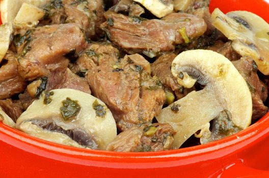 Beef Stew with Greens and Champignons closeup in Red Pan